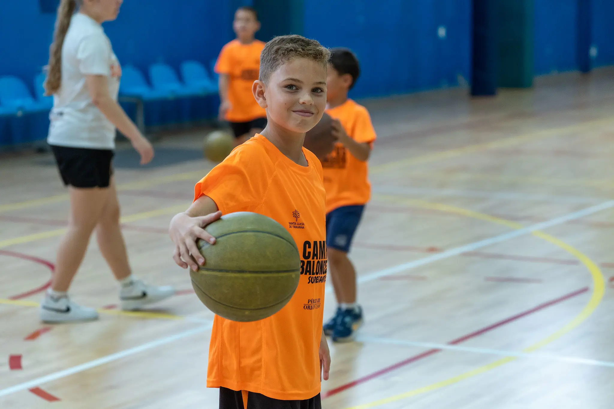 Niño con la camiseta del campus de baloncesto Suresanta sujetando un balón