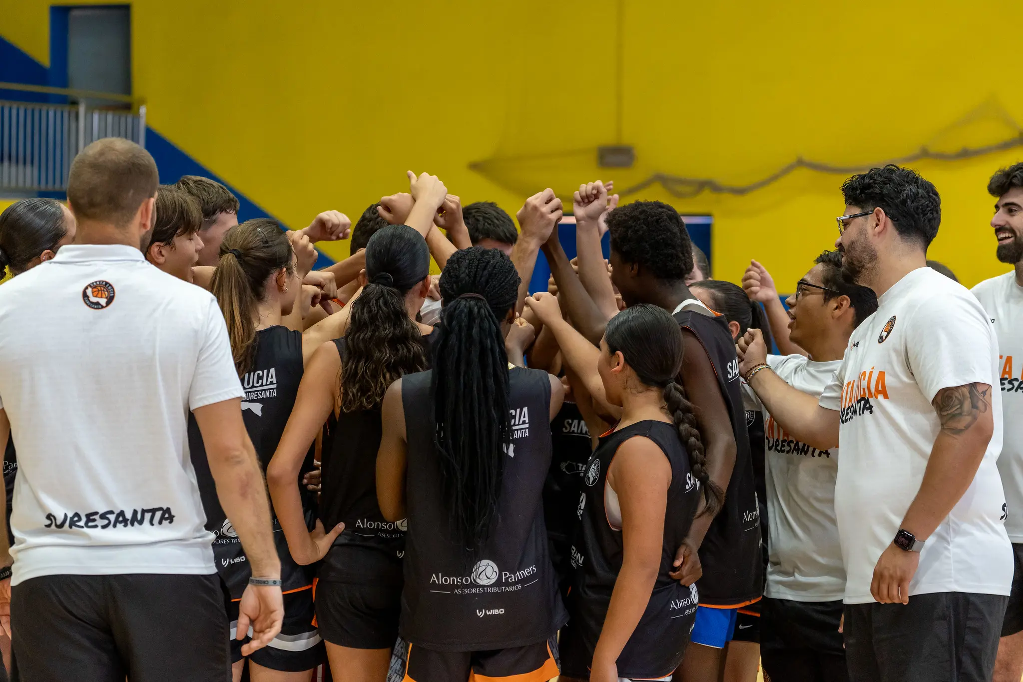 Jugadoras y cuerpo técnico haciendo la piña antes de un partido