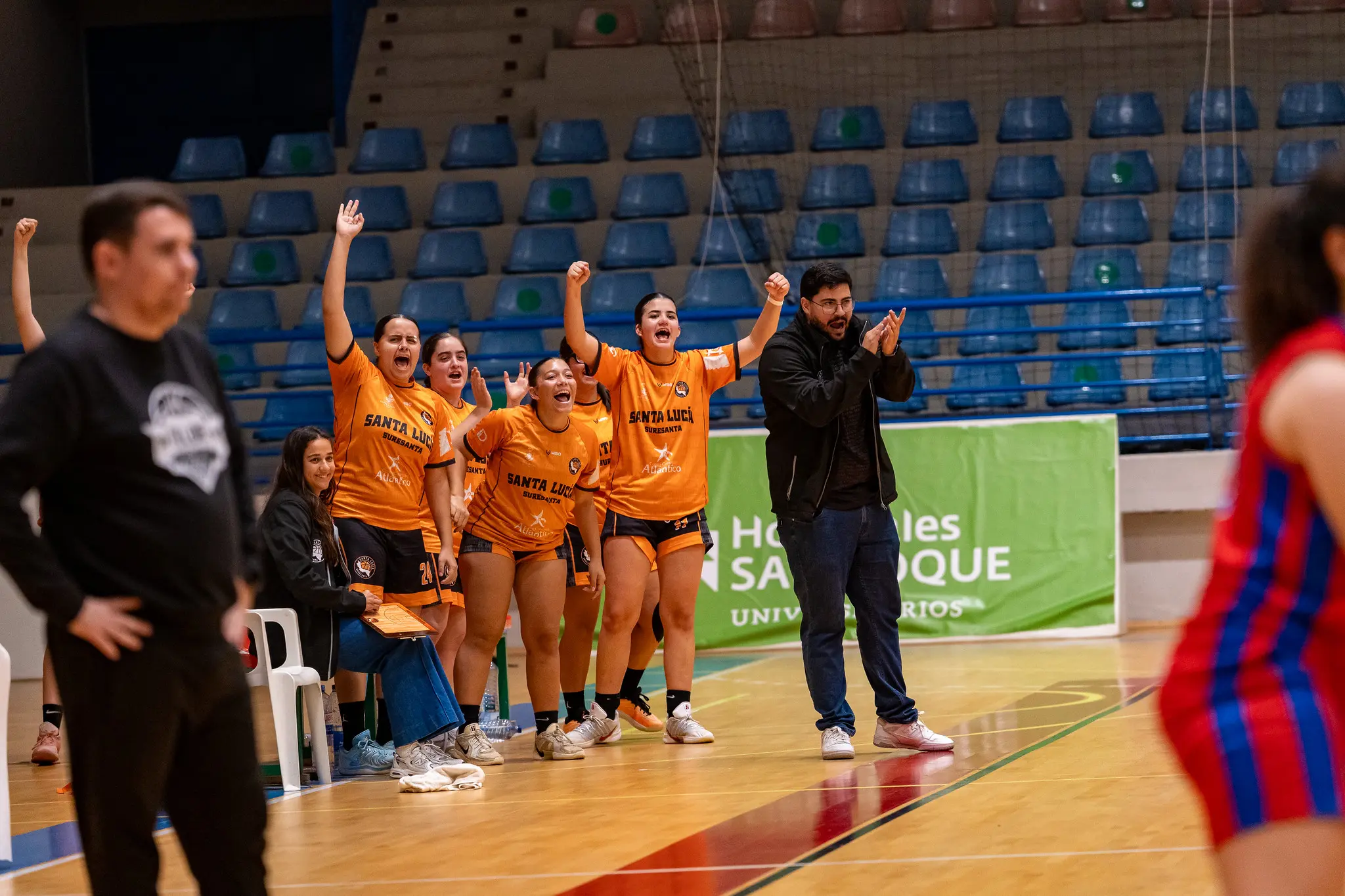 Banquillo del equipo femenino celebrando una jugada junto al entrenador